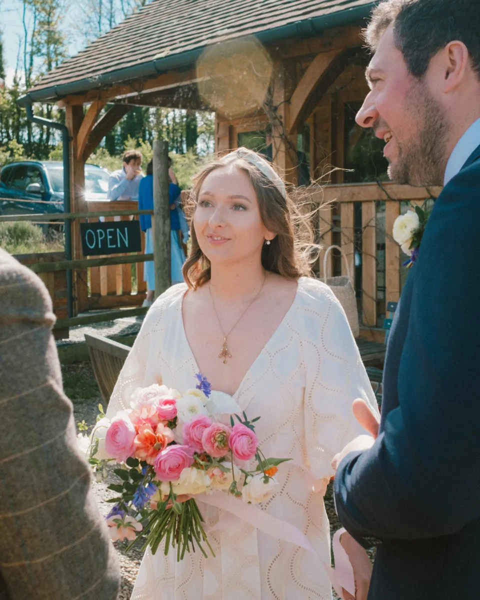 Tibbs Farm wedding - bride outside chatting to guests