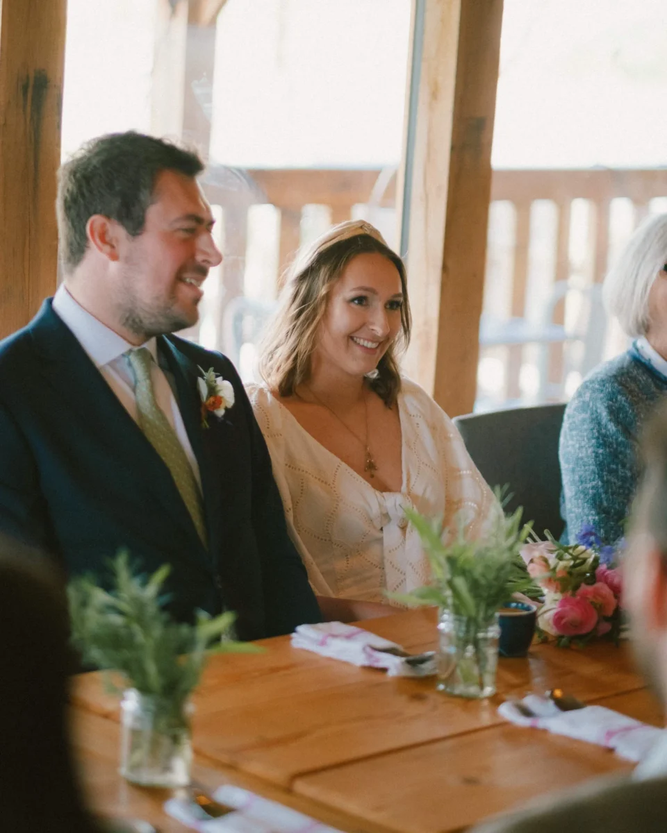 Tibbs Farm wedding - couple sitting for speeches in the cafe