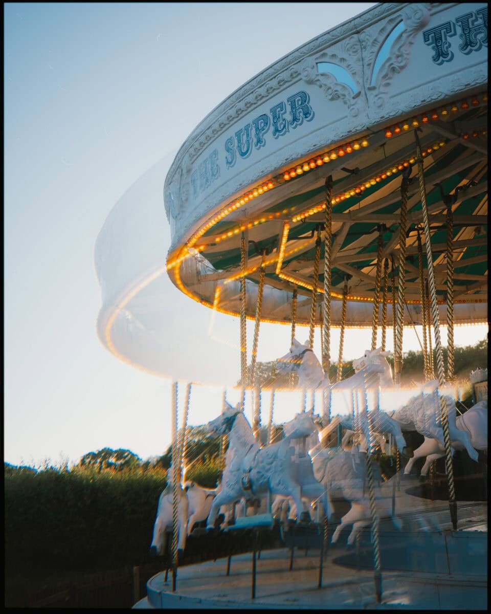 Vintage carousel spinning with white horses at Preston Court wedding venue.