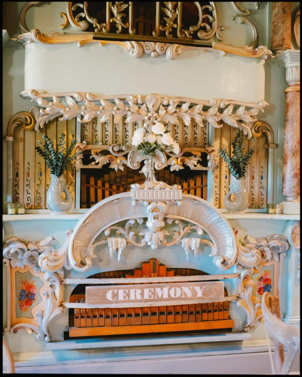 Decorated fairground organ with ceremony sign at Preston Court wedding venue in Kent.