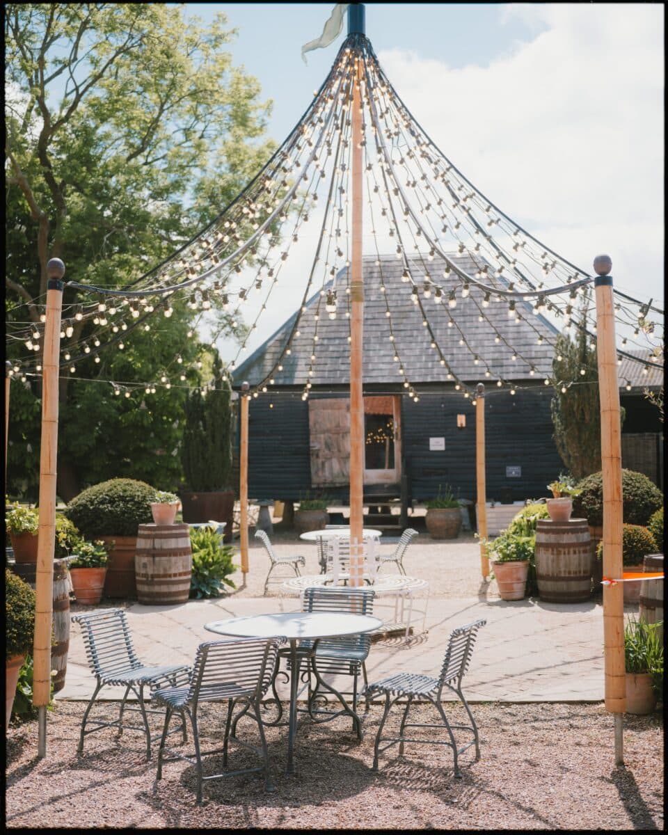 Courtyard with festoon lights and seating at Preston Court wedding venue in Kent.