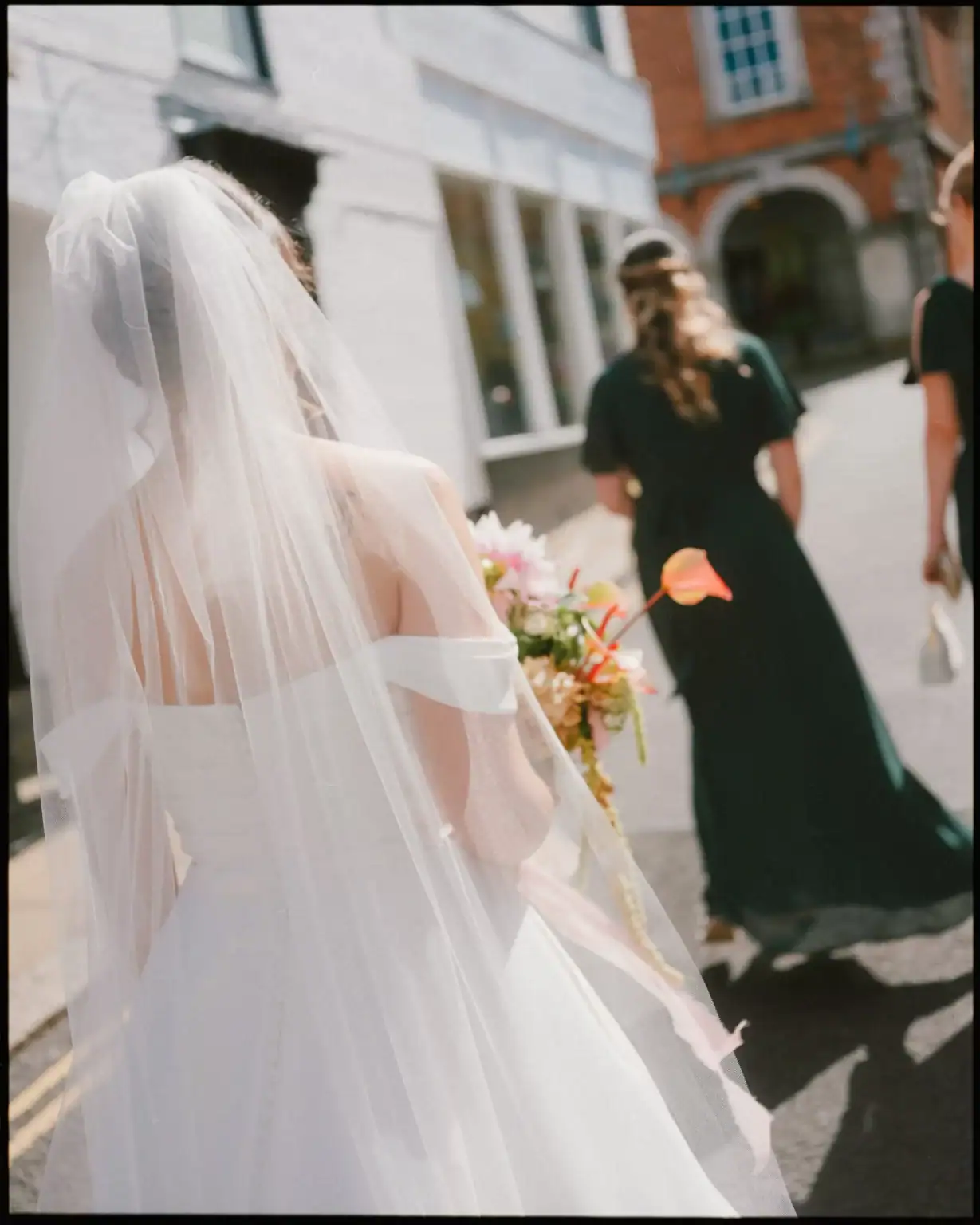 bride walking up to the town hall from the george in rye