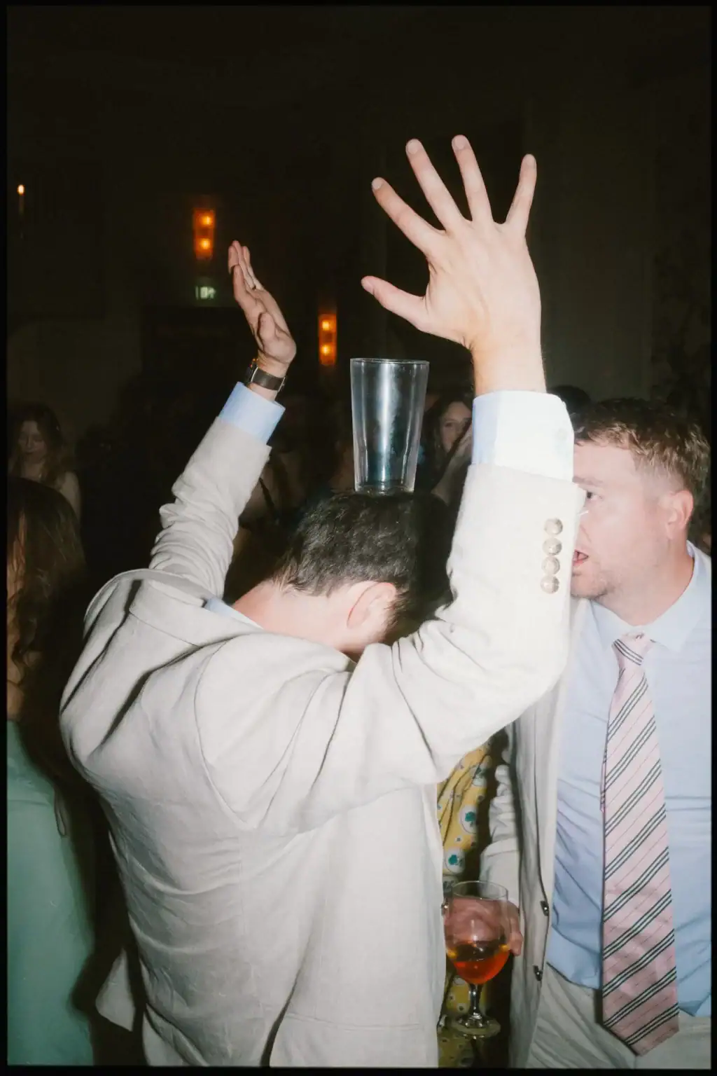 wedding guest partying with pint glass balanced on his head during band set at the george in rye