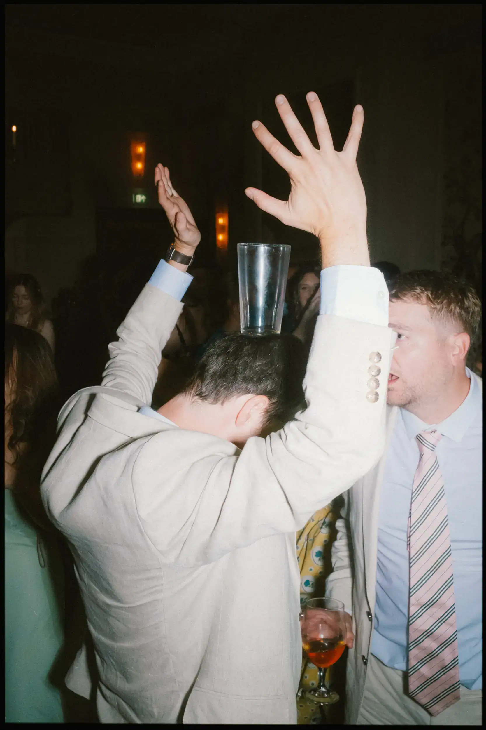 wedding guest partying with pint glass balanced on his head during band set at the george in rye