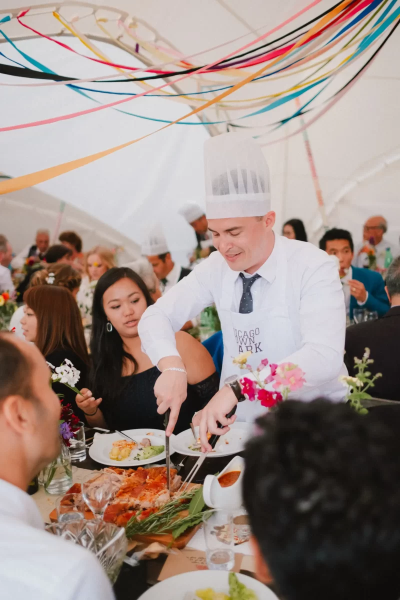 Guest cutting roast during the wedding breakfast at The Paper Mill woodland wedding venue in Kent.