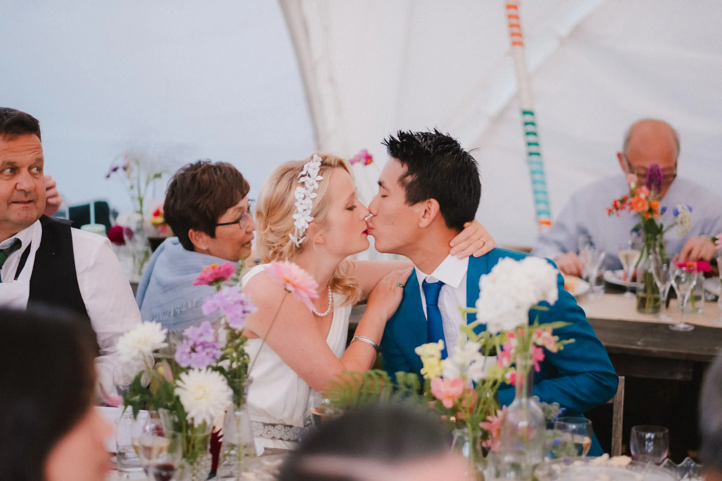 couple kissing during speeches at exclusive woodland wedding venue in kent