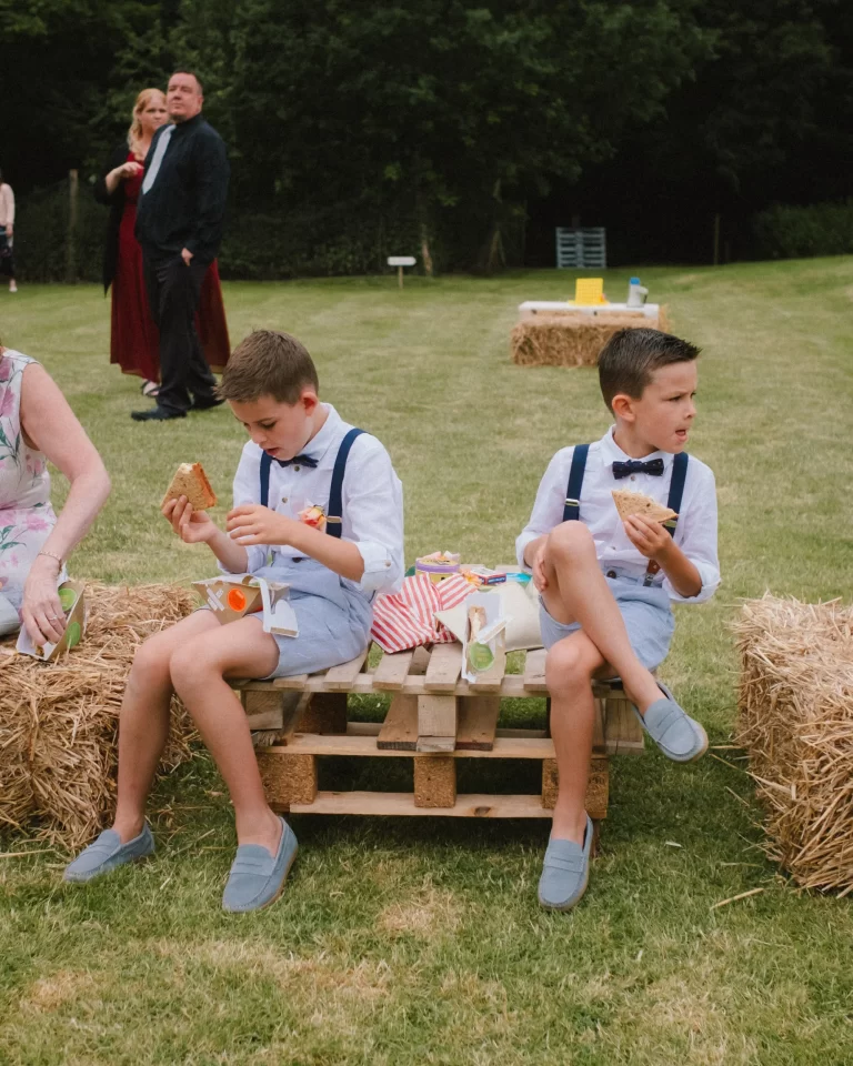 two boys having meal deal lunch on pallet at exclusive woodland wedding venue paper mill kent