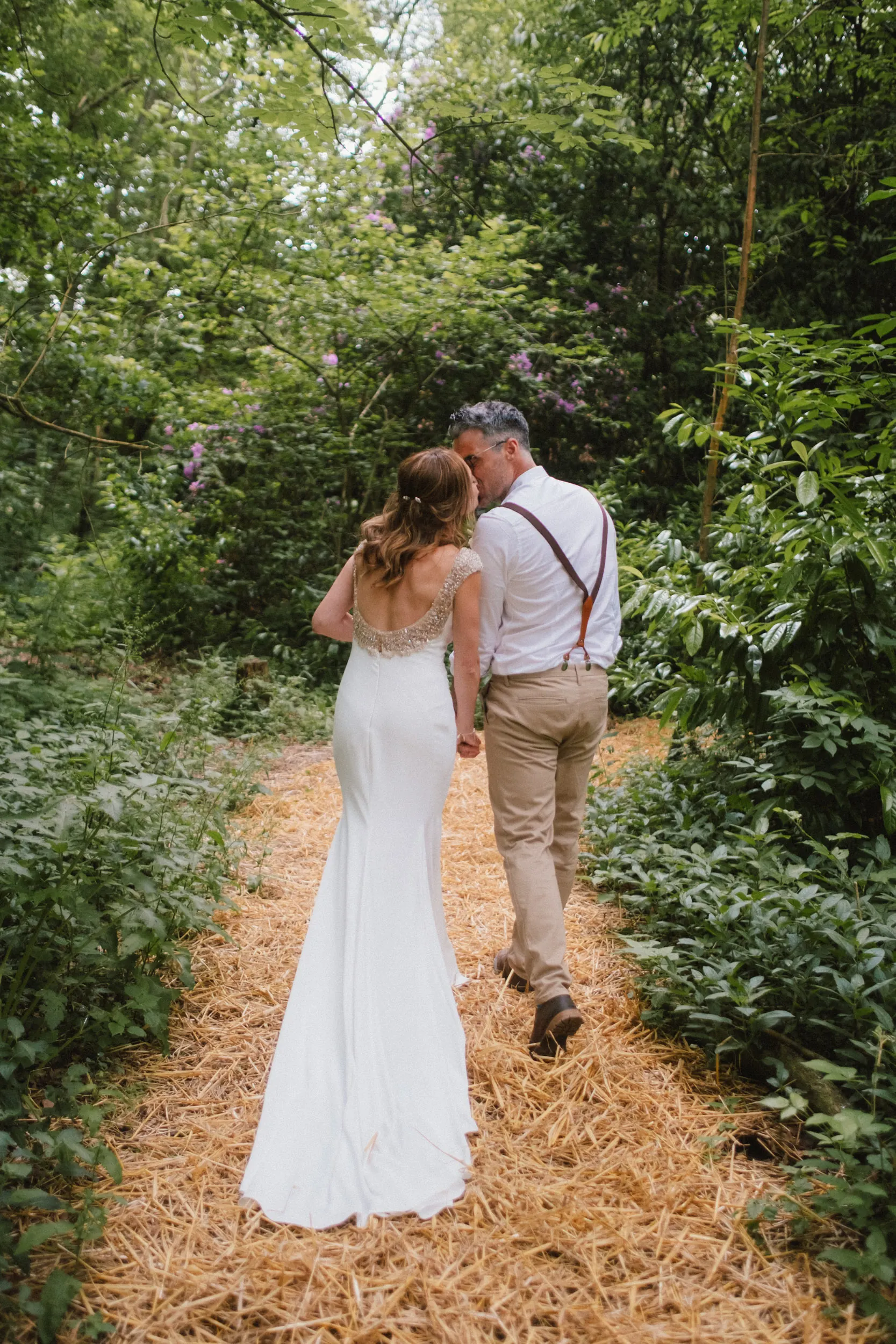 couple walking off after ceremony in the woods at exclusive woodland wedding venue paper mill kent