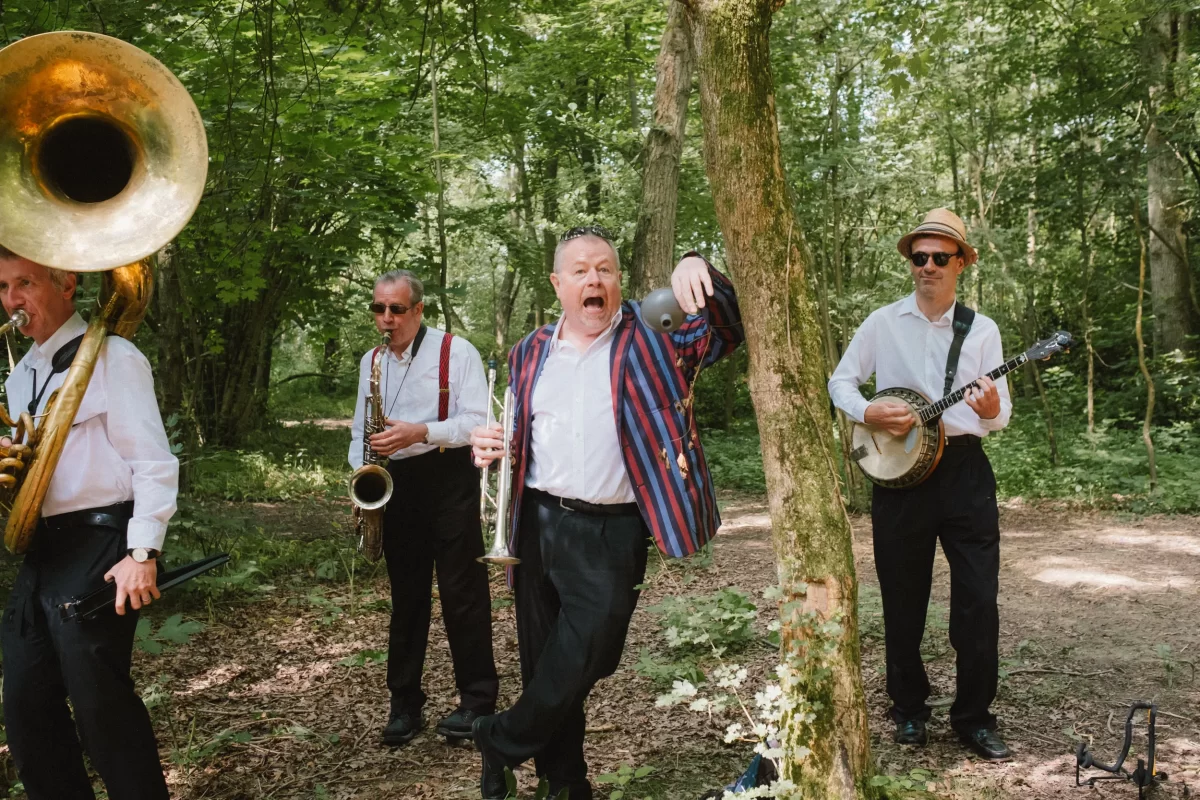 band playing brass instruments in the woods at exclusive woodland wedding venue kent