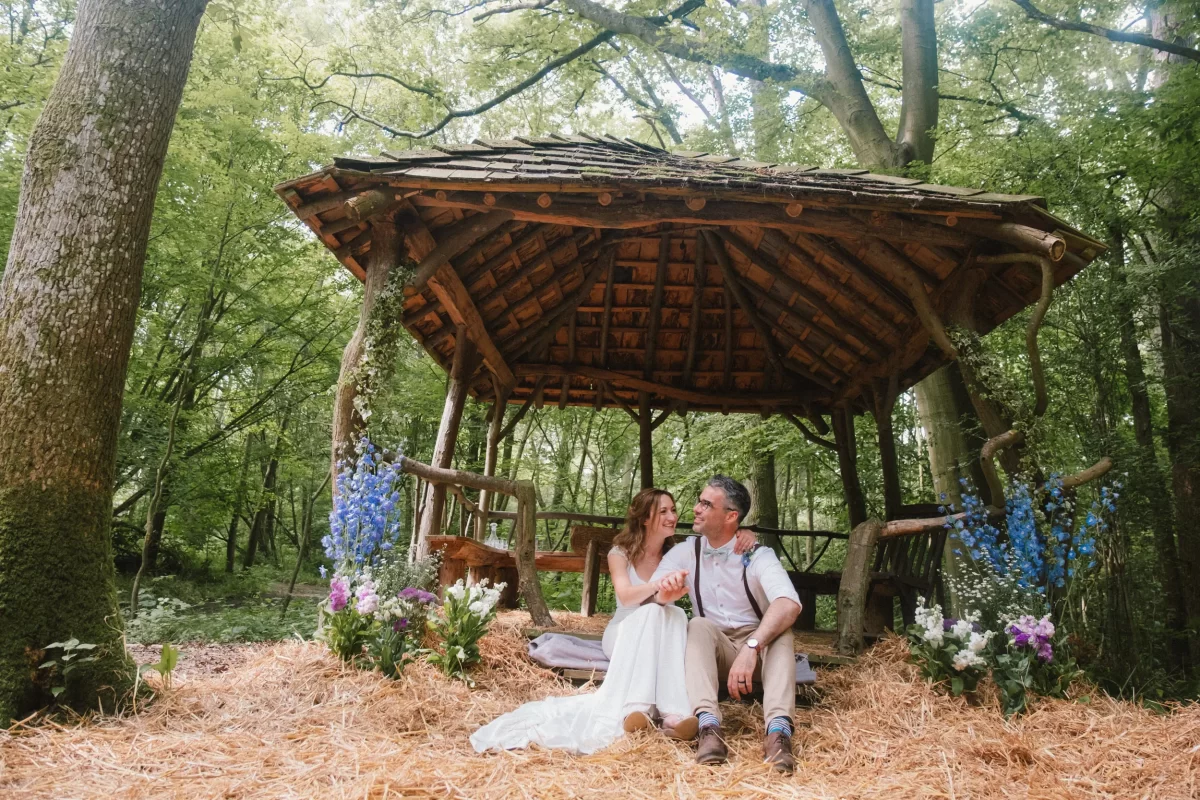 couple sat under pagoda after ceremony at exclusive woodland wedding venue paper mill kent