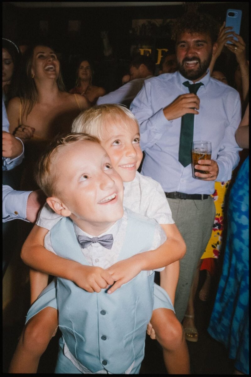 Two young brothers dancing and smiling during the evening wedding reception at The Bell in Ticehurst.
